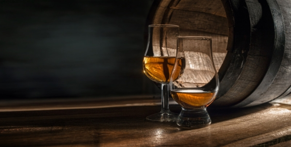 Rum in Gläßern vor Eichenholzfässern aus der Karibik
