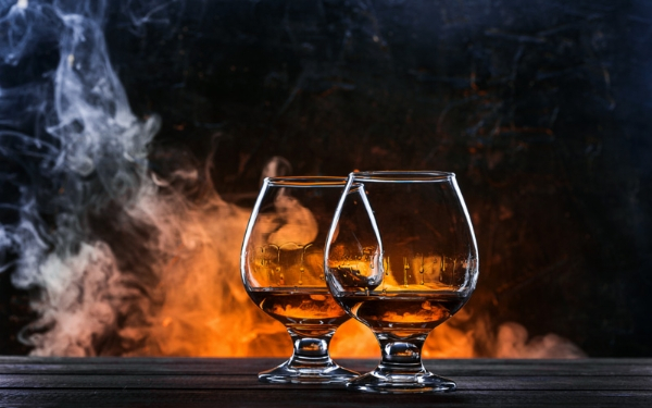 2 Gläser mit Rum gefüllt im Hintergrund ist Rauch zu sehen 