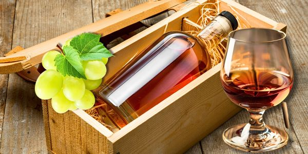 Kiste mit einer Flasche Branntwein und ein Glas Kiste mit einer Flasche Branntwein und ein Glas