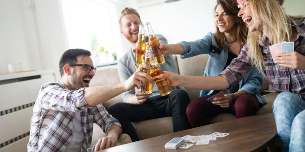 Kartenspieler beim anstoßen mit Bierflasche anstoßen mit Bierflasche beim Kartenspiel